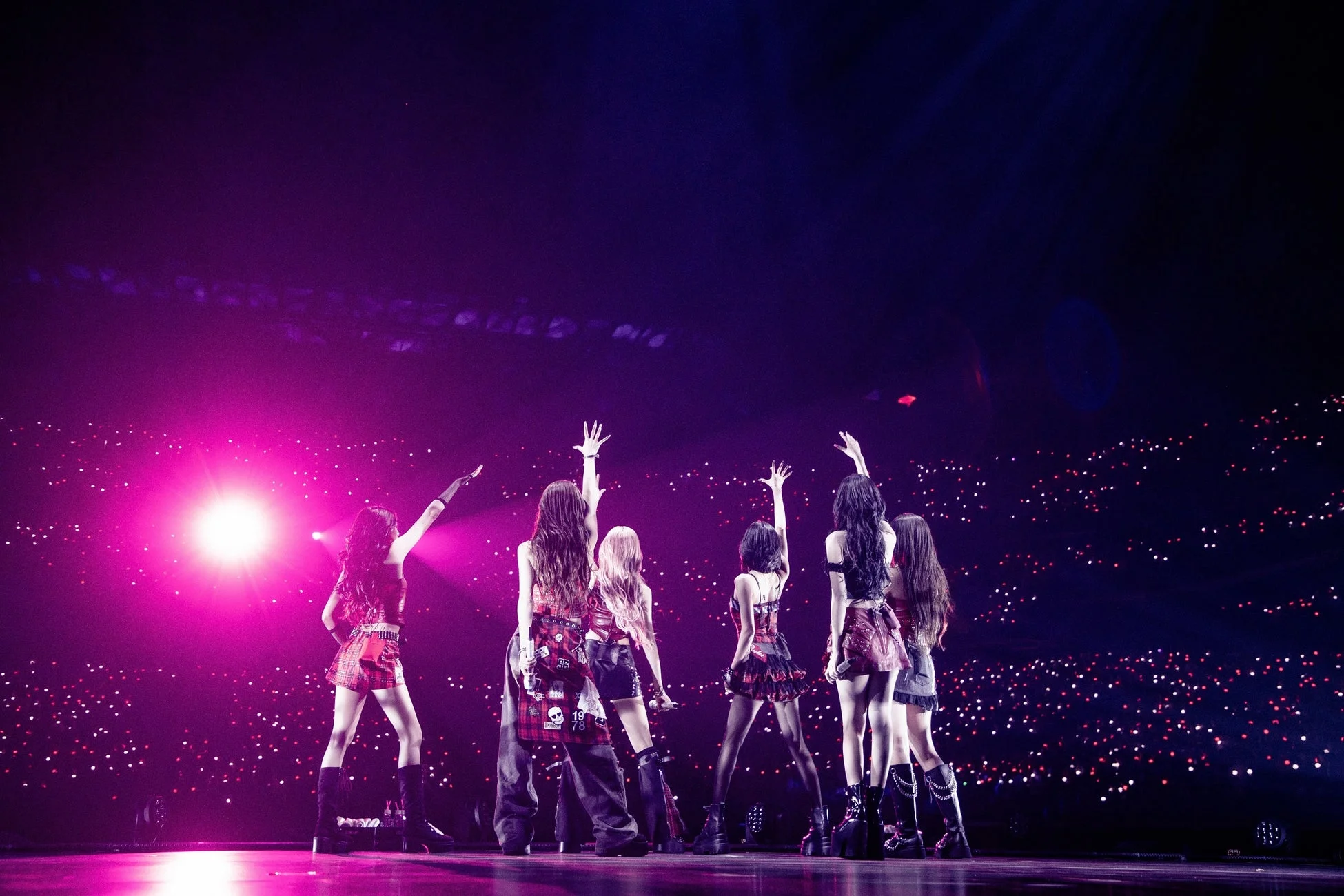 観客で埋め尽くされた会場でパフォーマンスするBABYMONSTERの後ろ姿