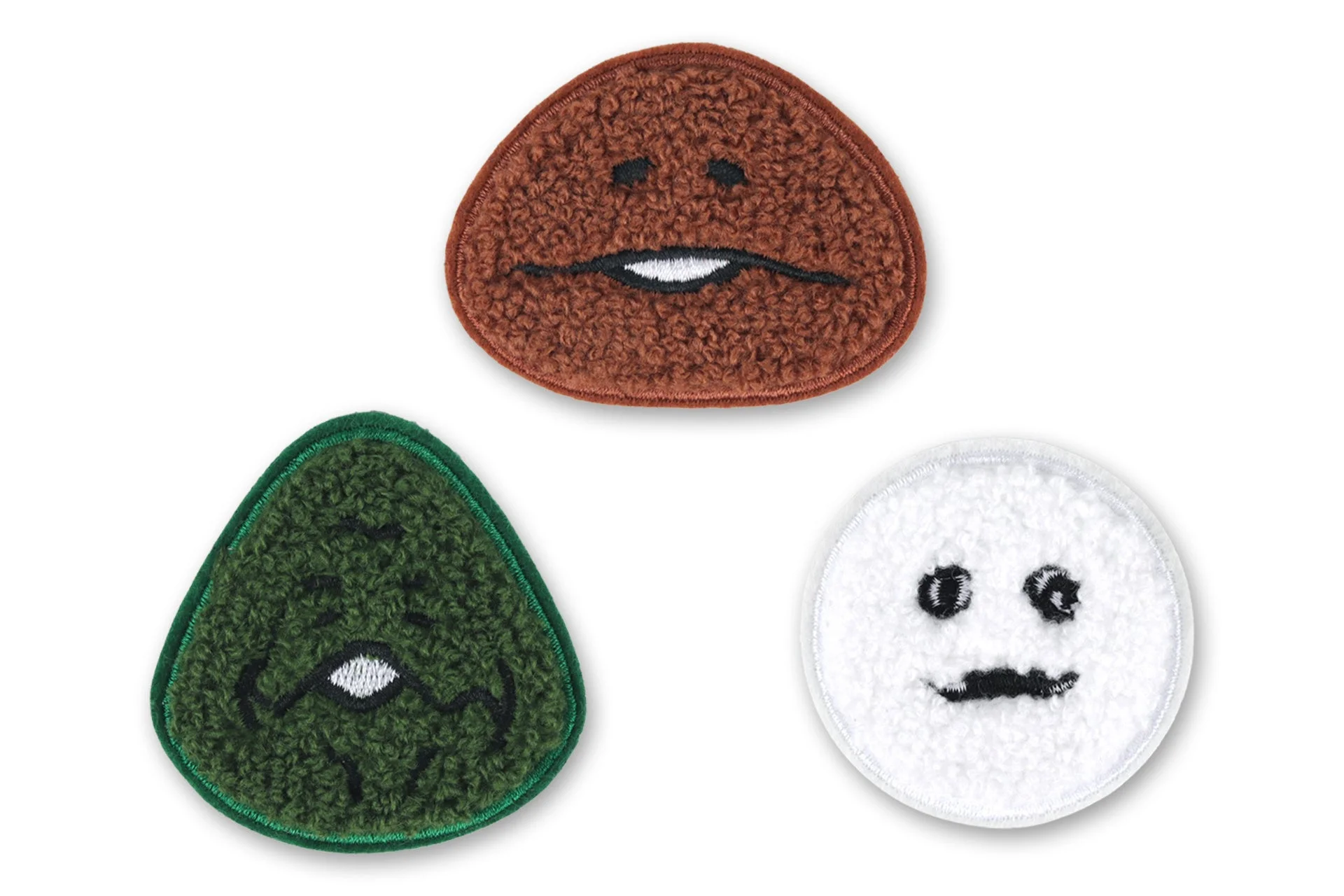 茶色、緑色、白色のフワフワした素材でできた顔のワッペンが3つ