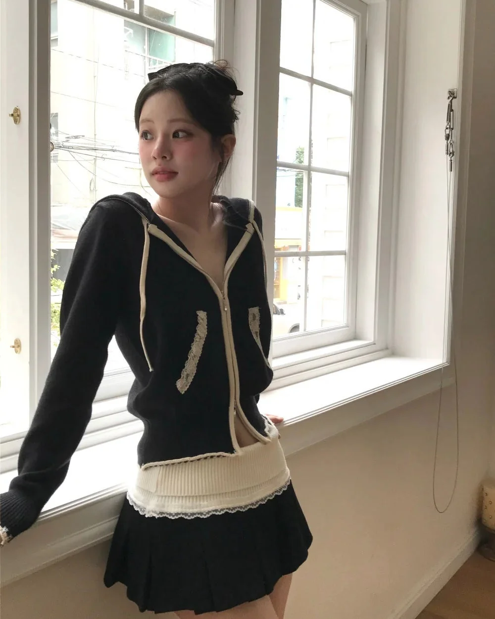 黒いパーカーとミニスカートを着用した若い女性