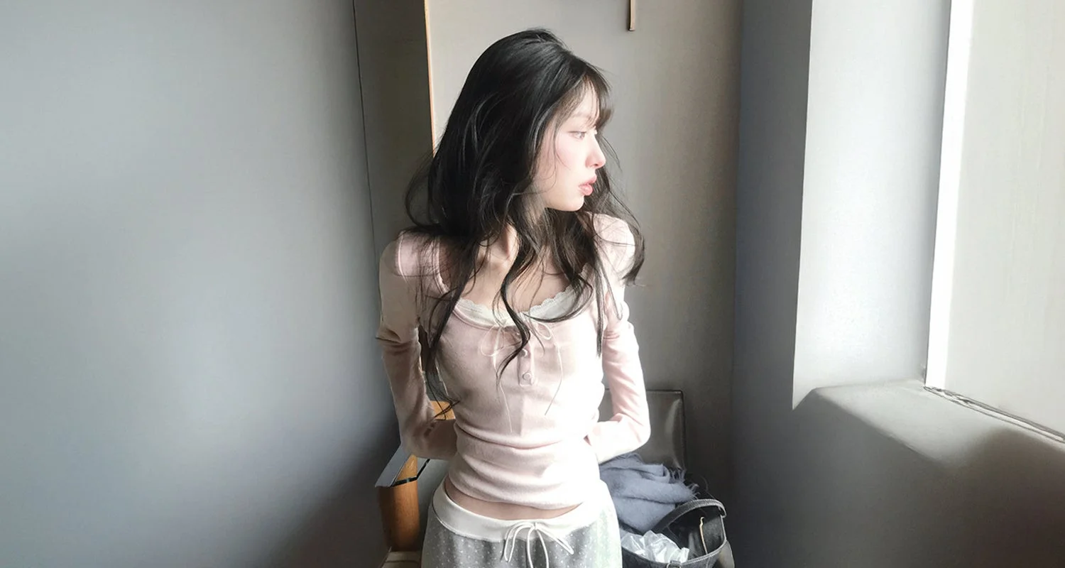 窓際に立つ若い女性