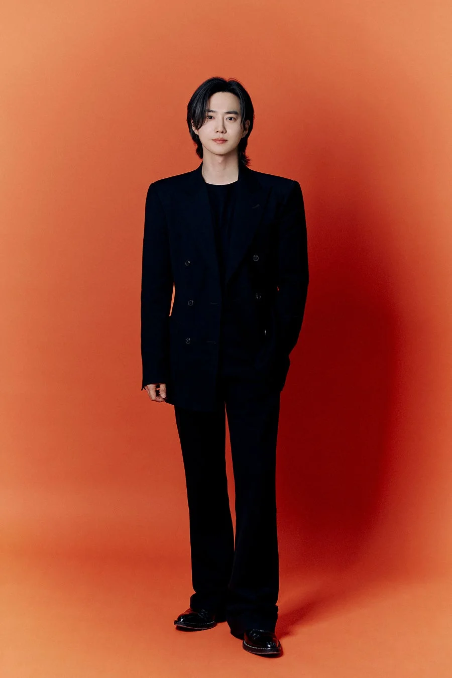 黒のダブルブレストスーツを着たスホさんの全身