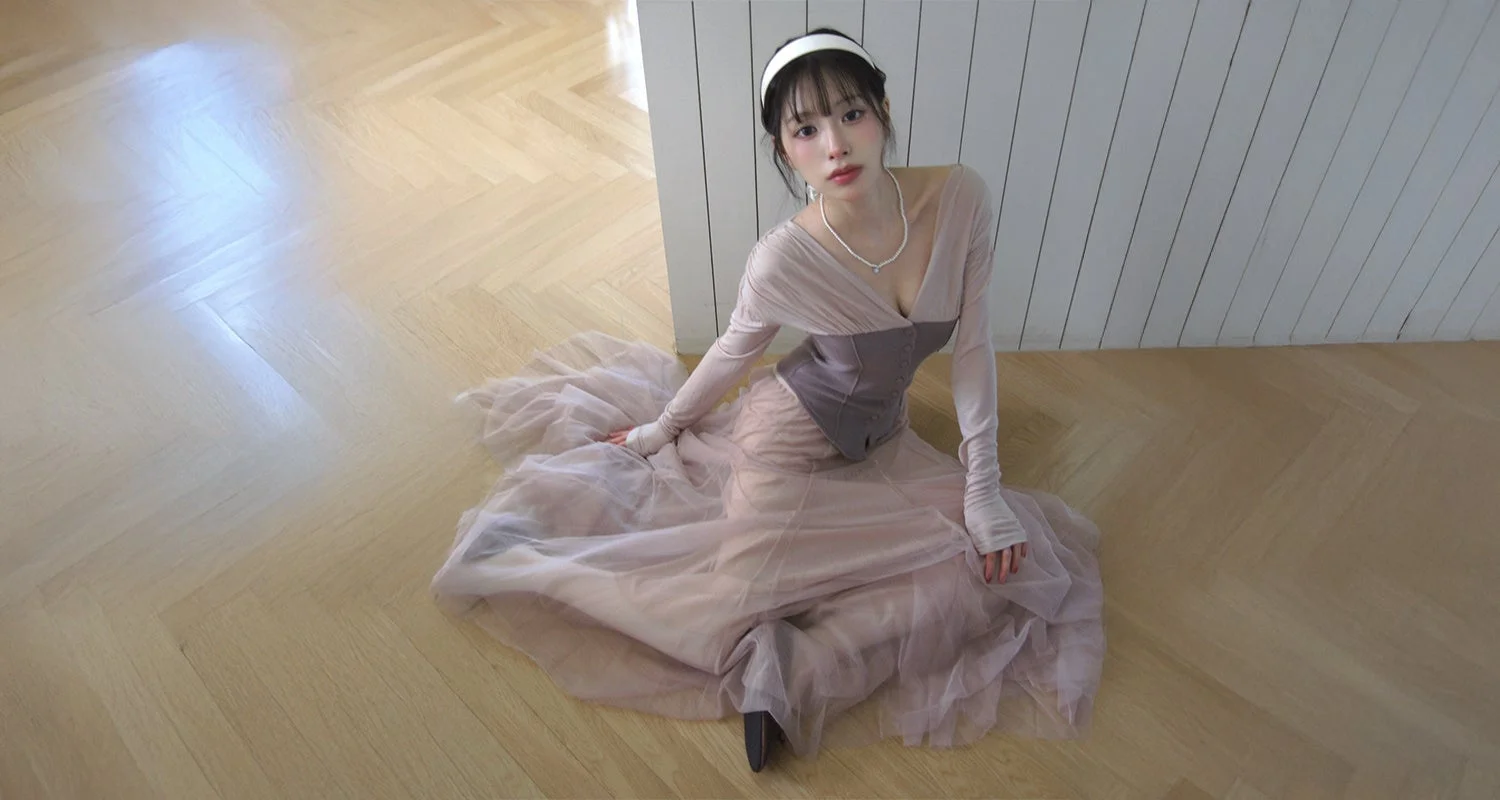 淡いピンクベージュのドレスとコルセットを着用した女性