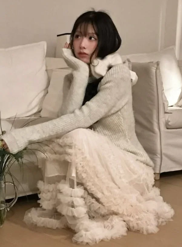 白いソファにもたれて床に座る若い女性