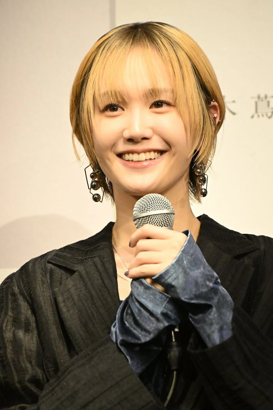 笑顔でマイクを持つ尾碕真花さん