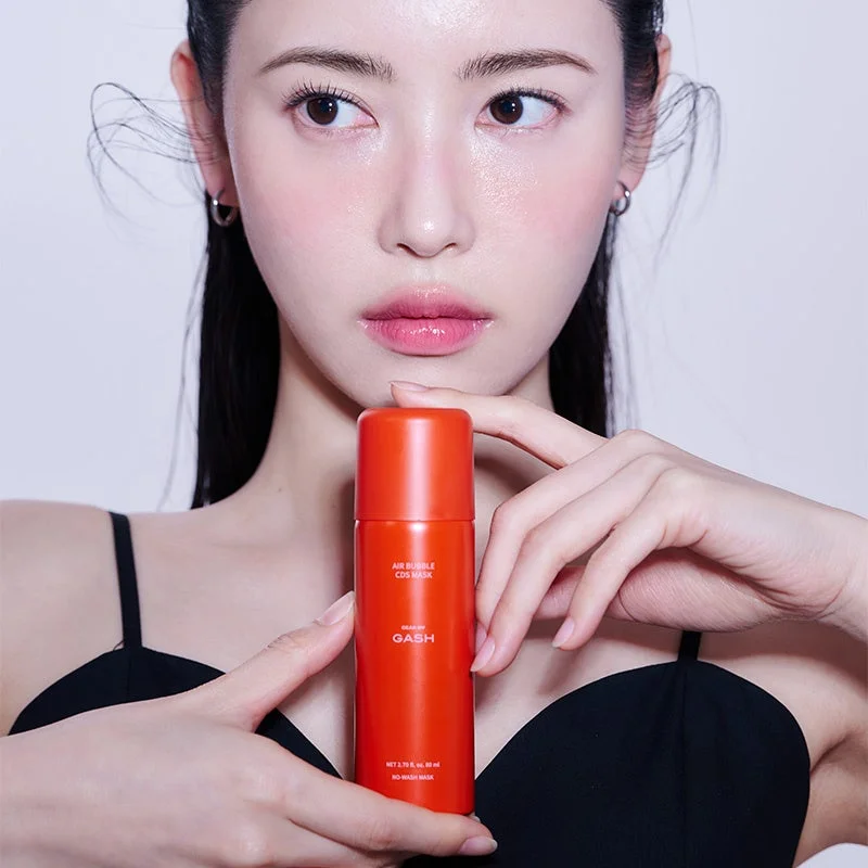 女性とオレンジ色の化粧品ボトル