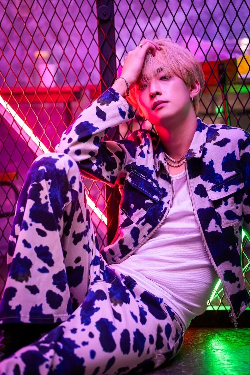 ネオンライトを背景に座るホジンさん