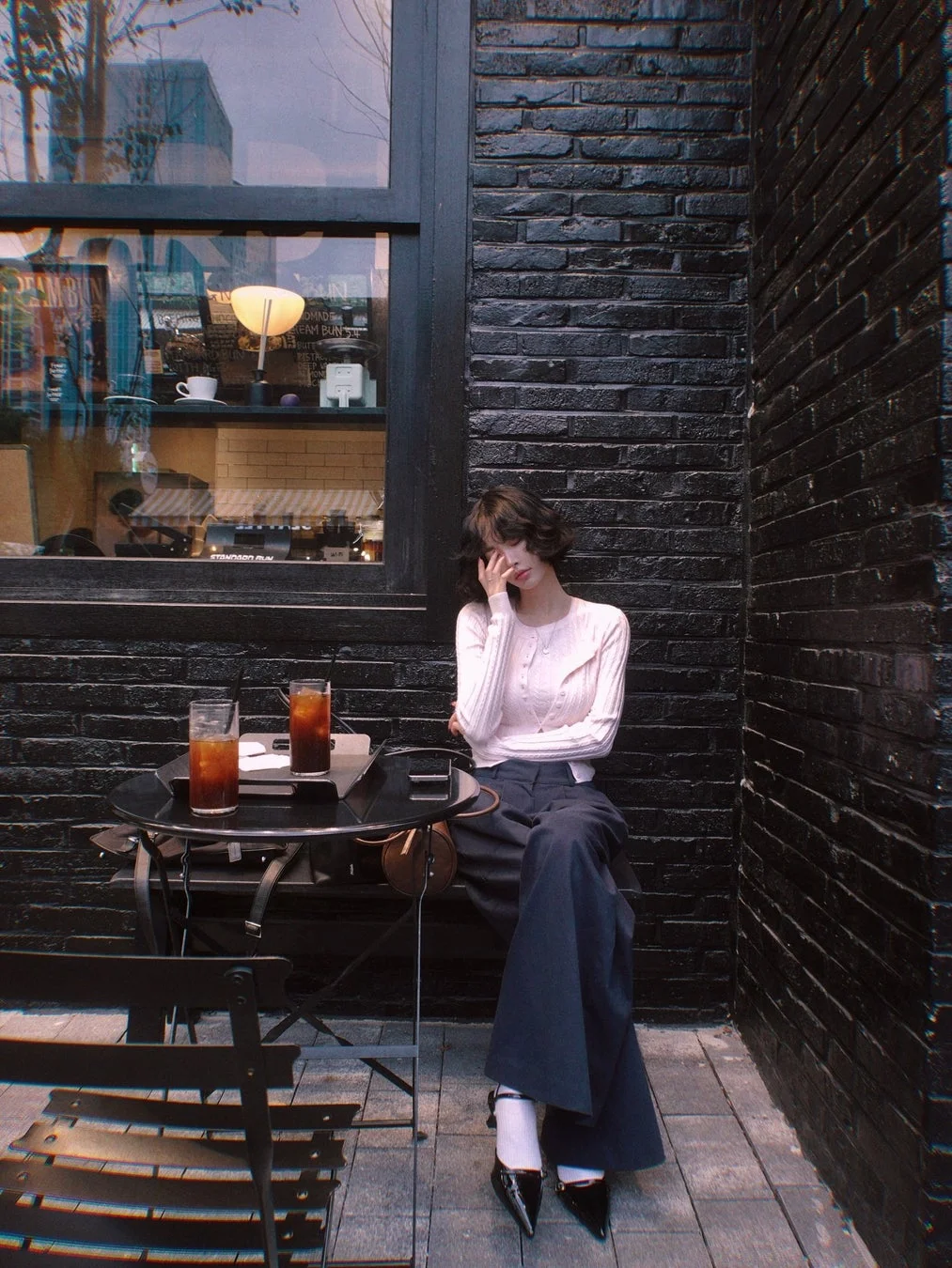 女性がカフェの屋外席にいる様子