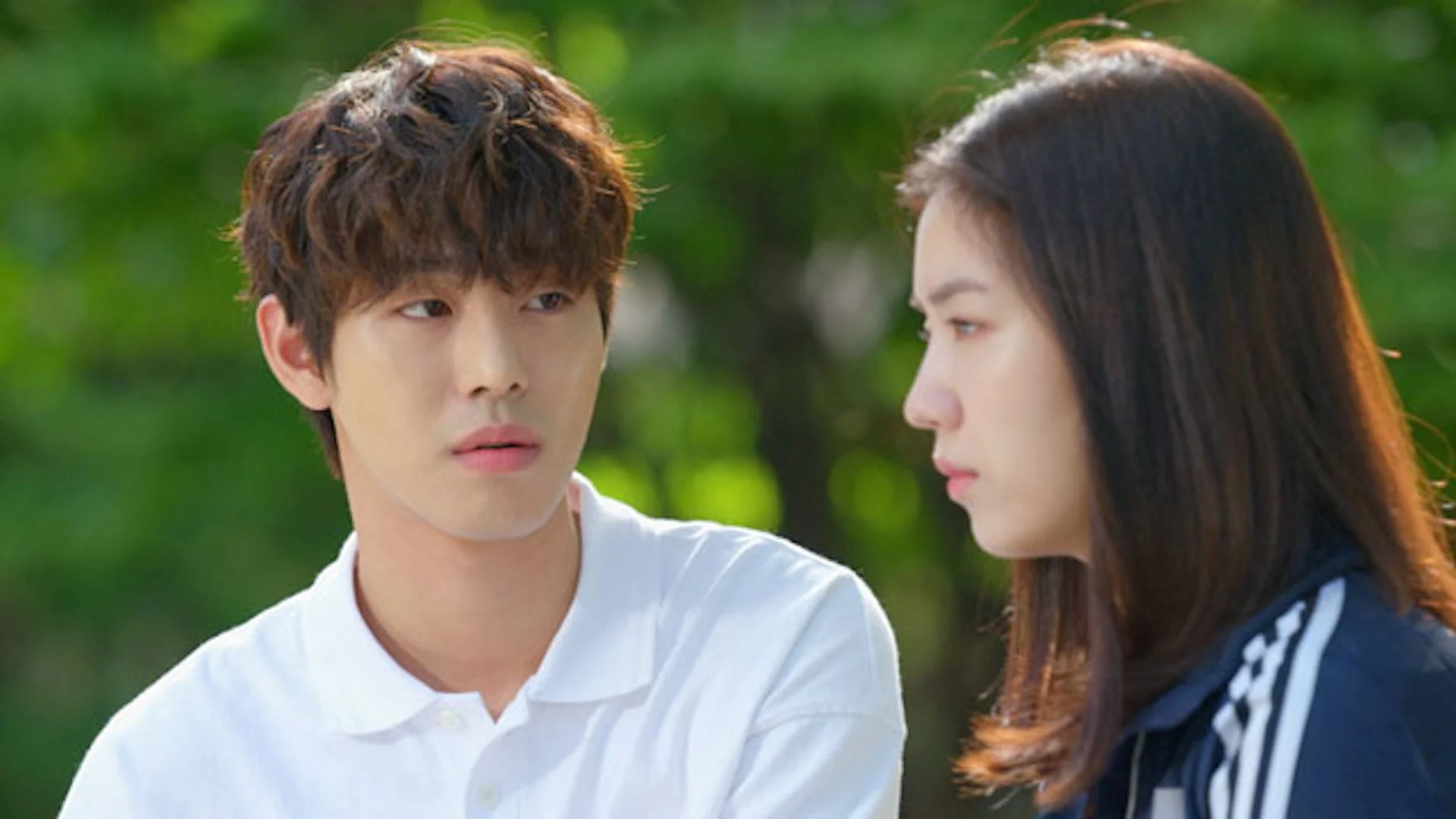 緑豊かな屋外で向かい合う若い男女