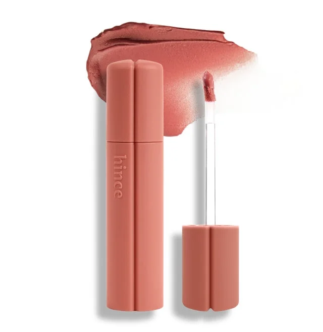 hinceのリップティントが白い背景に置かれ、その液体リップの本体、アプリケーター、そしてピーチ系の色味がスウォッチとして示されています。化粧品製品の鮮明なイメージです。