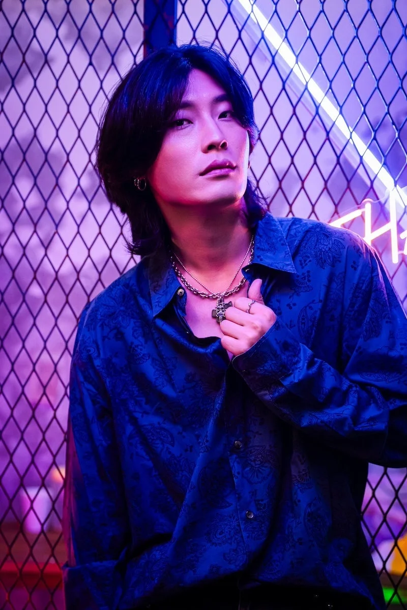 ネオンライトを背景に立つジュノンさん