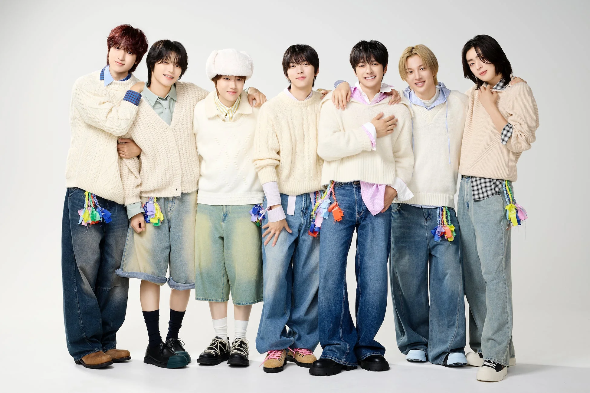 7人の若い男性アイドルグループがカジュアルなファッションに身を包み、笑顔でポーズをとっている集合写真