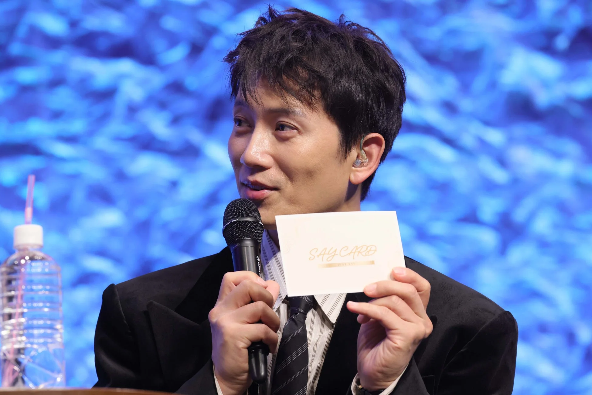 マイクとカードを持つ男性