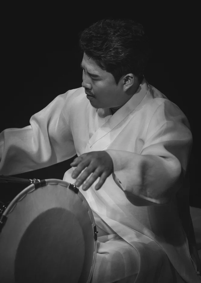 チャンゴを演奏するイ・ジュニョン氏の白黒写真