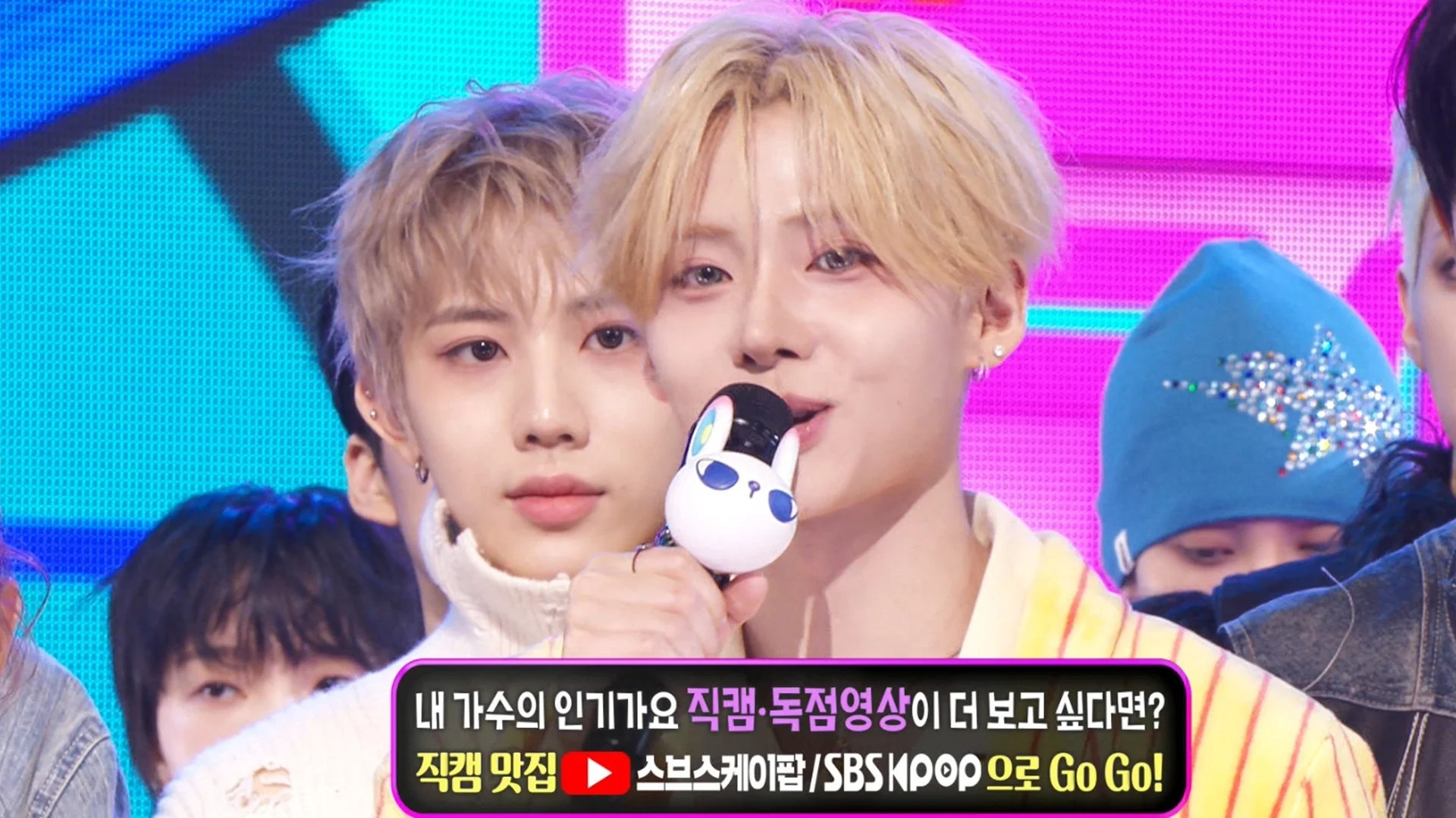 ステージ上でマイクを持つ男性K-POPアイドル