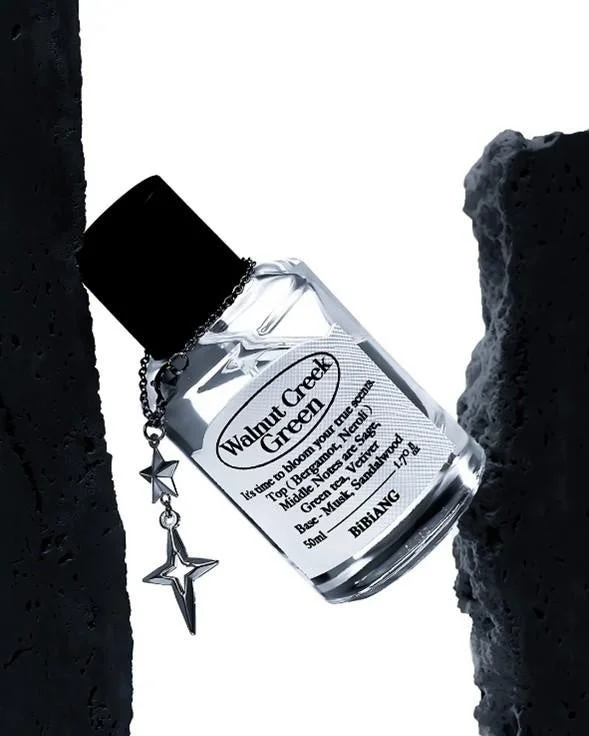 「Walnut Creek Green」という名前の香水ボトルが、星型のチャームとともに黒い岩のようなオブジェクトの間に置かれています