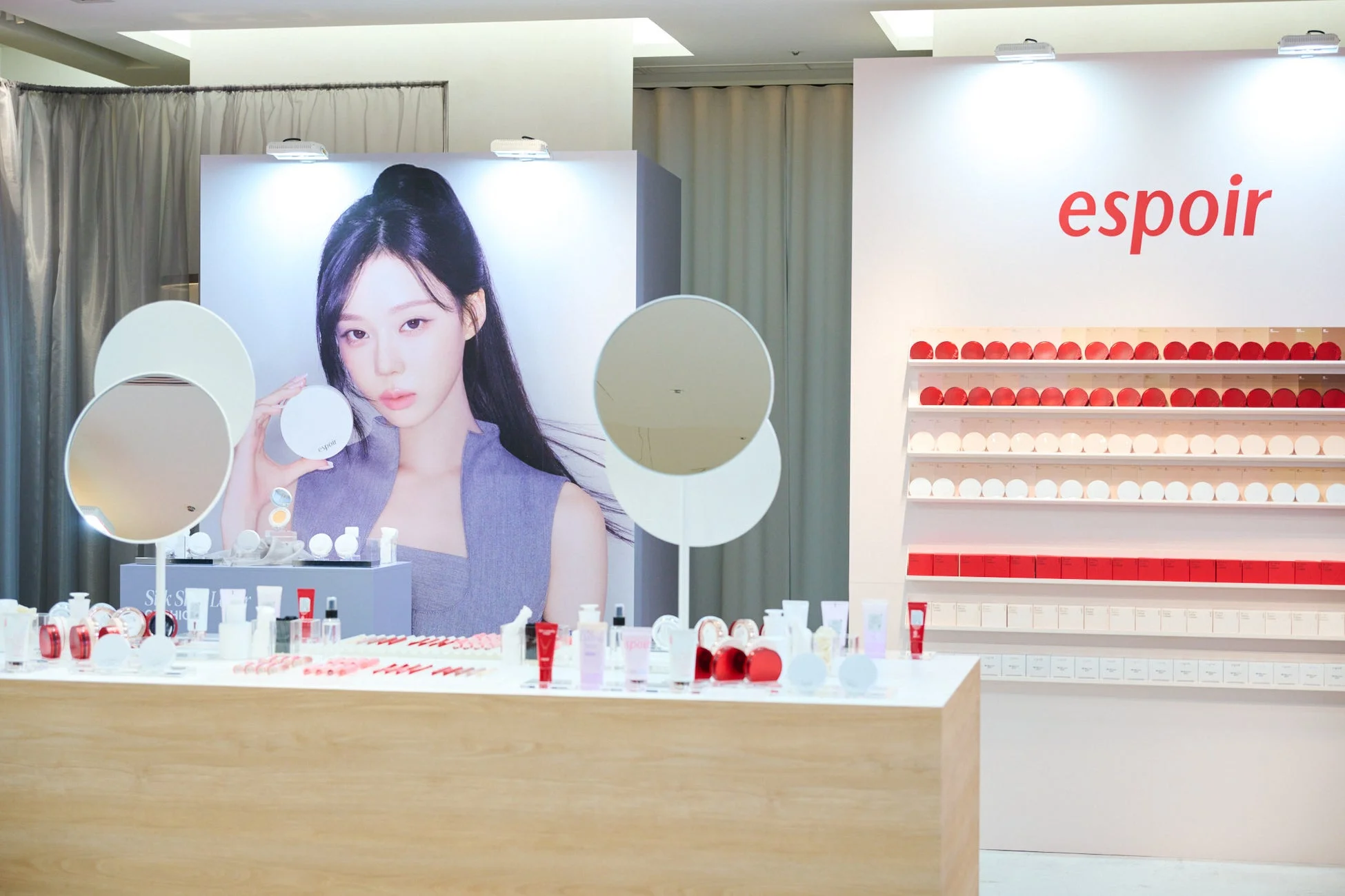 「espoir」ブランドの化粧品展示コーナーの様子。モデルのポスターが飾られ、カウンターや棚には様々なメイクアップ製品が整然と陳列されています。
