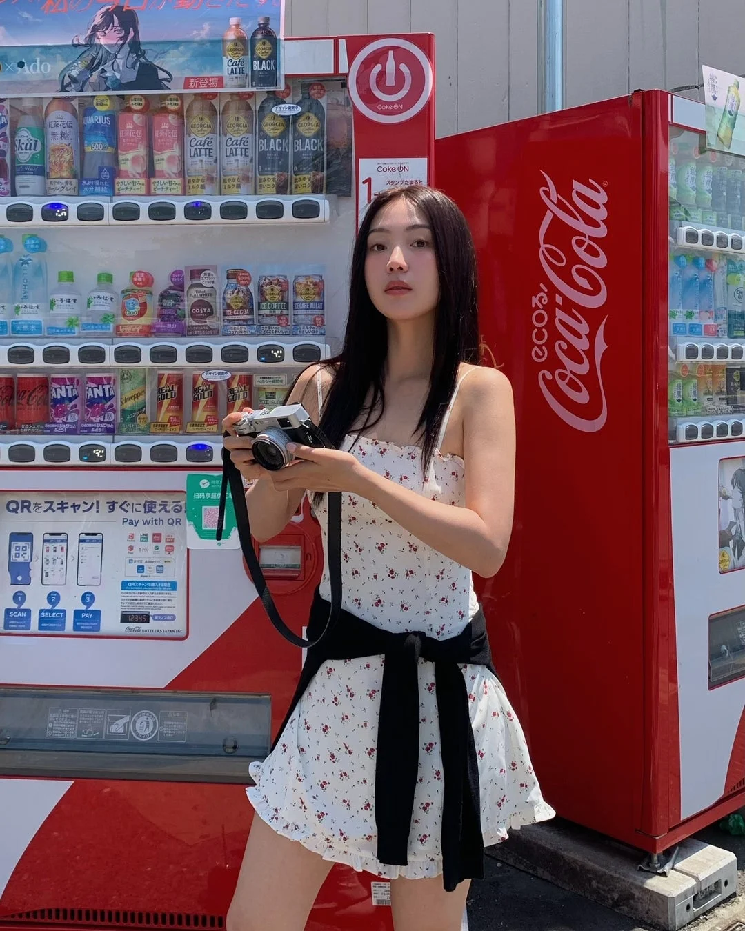 日本の自動販売機の前でカメラを構える女性