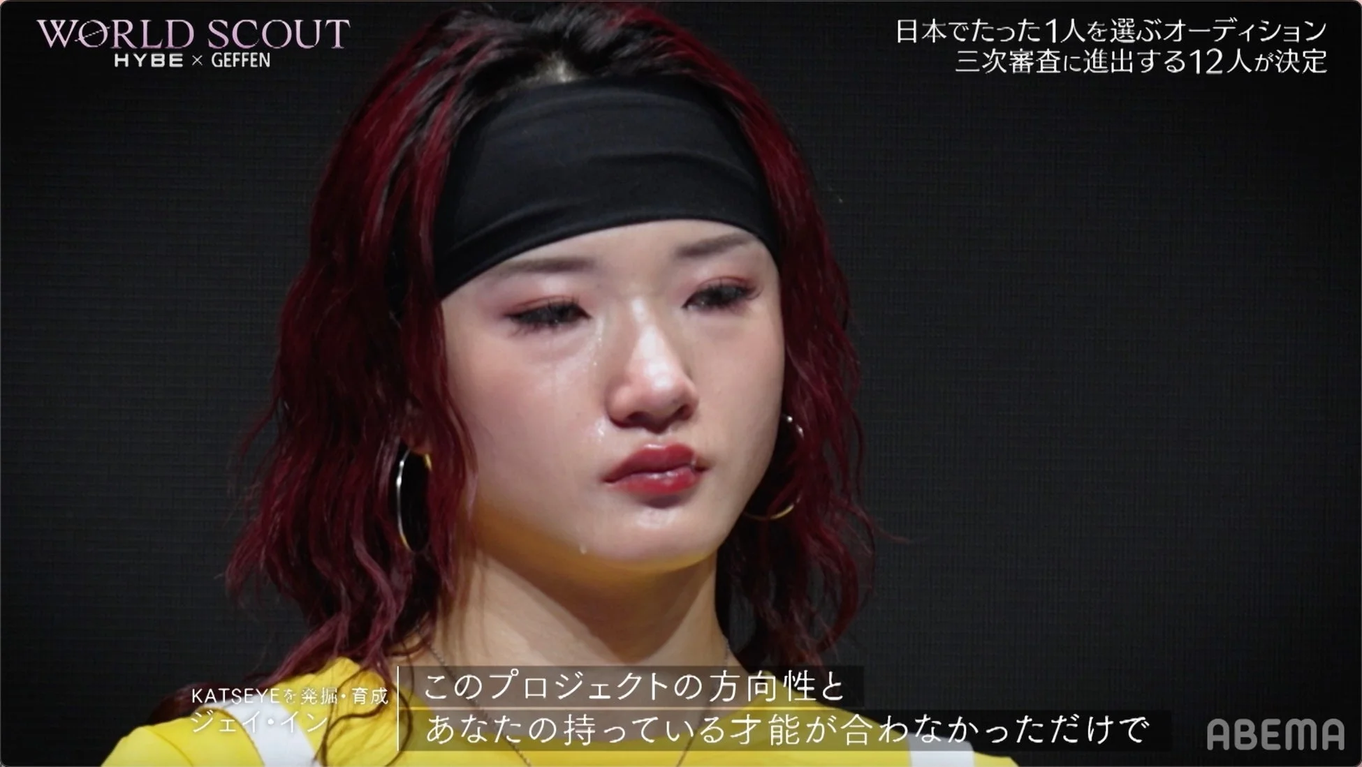 オーディション番組の一場面で、涙を流す女性参加者のクローズアップ