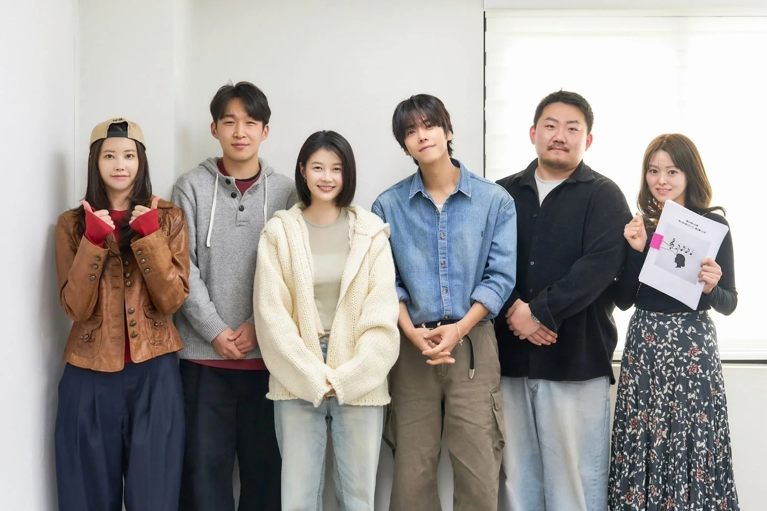 白い壁の前で男女6人が笑顔で並んでいる集合写真