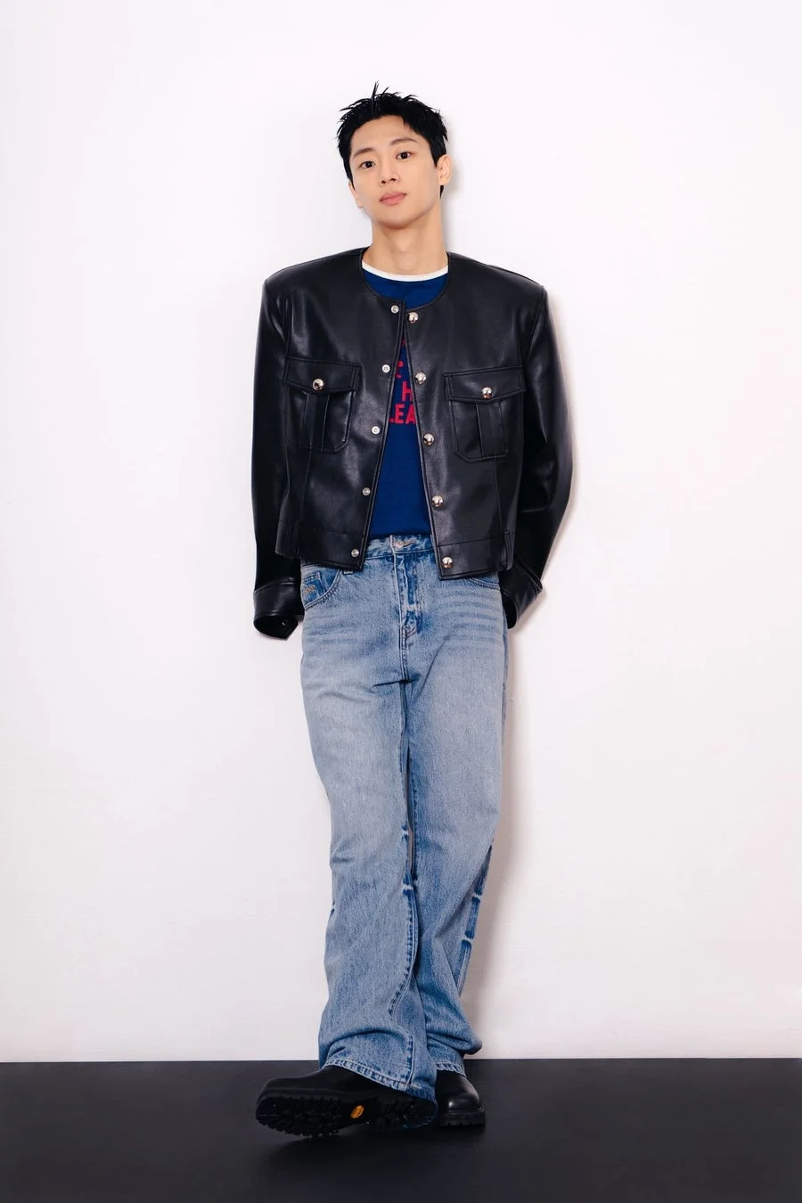 黒いレザージャケットとライトブルーのジーンズを着用したイ・シニョンの全身ポートレート