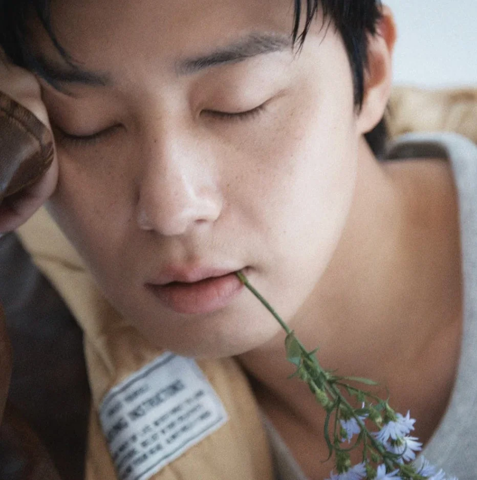 目を閉じて花をくわえる男性のポートレート