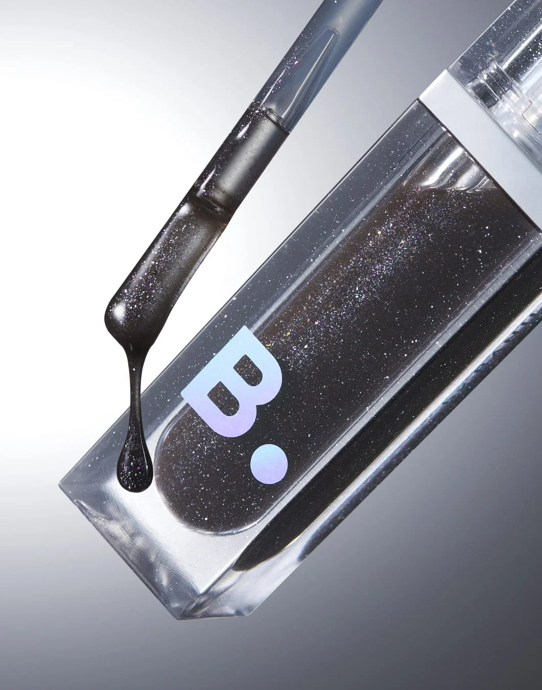 黒いグリッターが入った液体コスメのボトルとスポイト